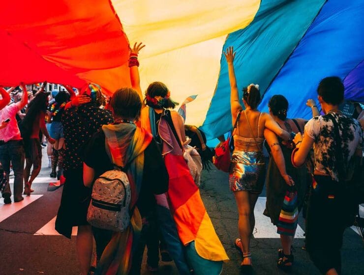 dance party under rainbow flag tent