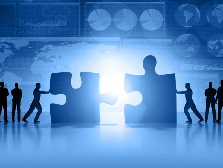people pushing giant puzzle pieces together